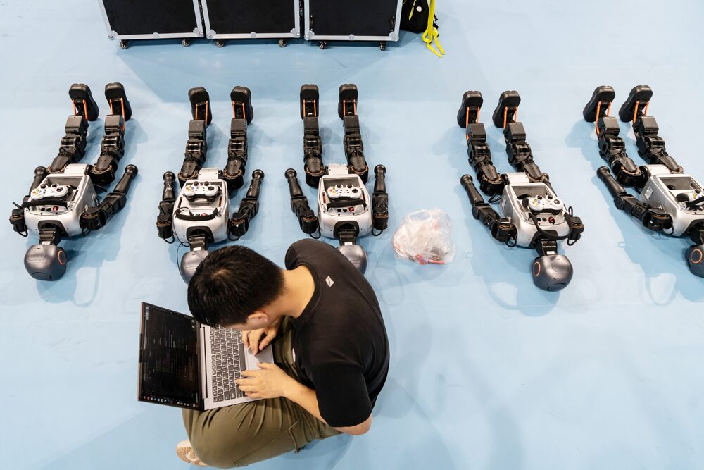 Um técnico programa robôs humanoides antes de uma partida de futebol (Foto: Qilai Shen/Bloomberg) Um técnico programa robôs humanoides antes de uma partida de futebol (Foto: Qilai Shen/Bloomberg)