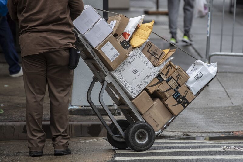 A United Parcel Service Inc. (UPS) driver pushes a trolley with Amazon boxes during a delivery in New York, U.S. A United Parcel Service Inc. (UPS) driver pushes a trolley with Amazon boxes during a delivery in New York, U.S.