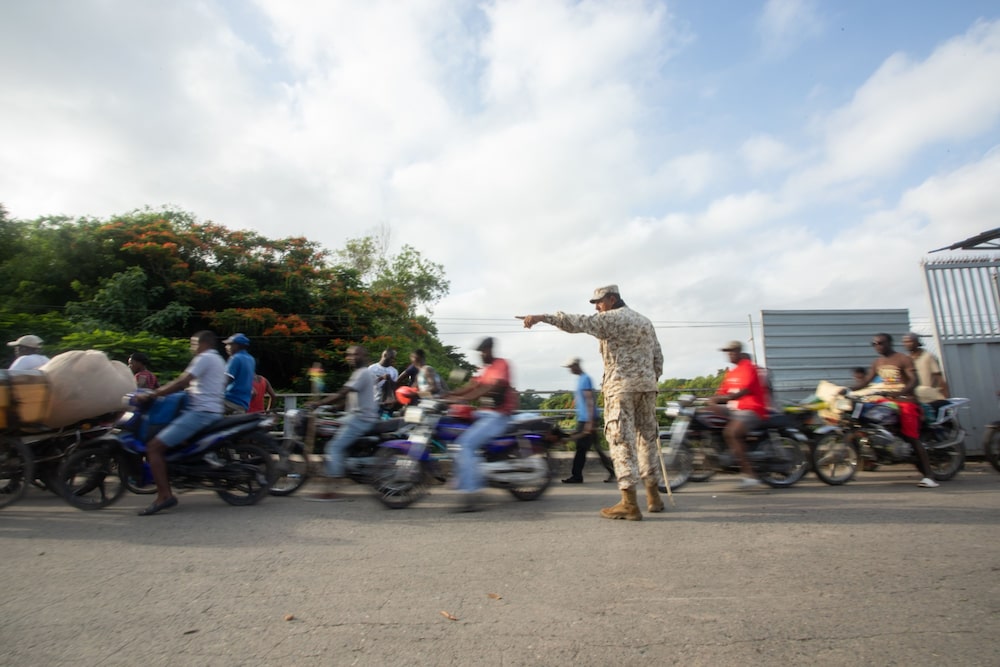 A Specialized Corps of Land Border Security agents directs Haitians entering a border crossing in Dajabón. A Specialized Corps of Land Border Security agents directs Haitians entering a border crossing in Dajabón.