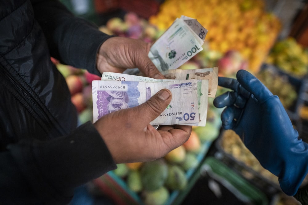 Un comprador paga por productos en un mercado de alimentos en Bogotá, Colombia, el jueves 30 de marzo de 2023. Un comprador paga por productos en un mercado de alimentos en Bogotá, Colombia, el jueves 30 de marzo de 2023.