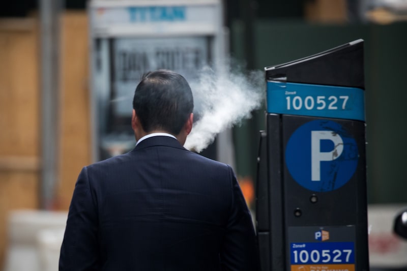Una persona de espaldas fumando un cigarrillo electrónico Una persona de espaldas fumando un cigarrillo electrónico