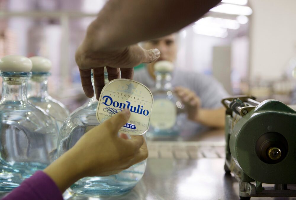 Un trabajador aplica una etiqueta a una botella de tequila Don Julio Blanco, en Guadalajara, México. Fotografia: Susana González/Bloomberg. Un trabajador aplica una etiqueta a una botella de tequila Don Julio Blanco, en Guadalajara, México. Fotografia: Susana González/Bloomberg.