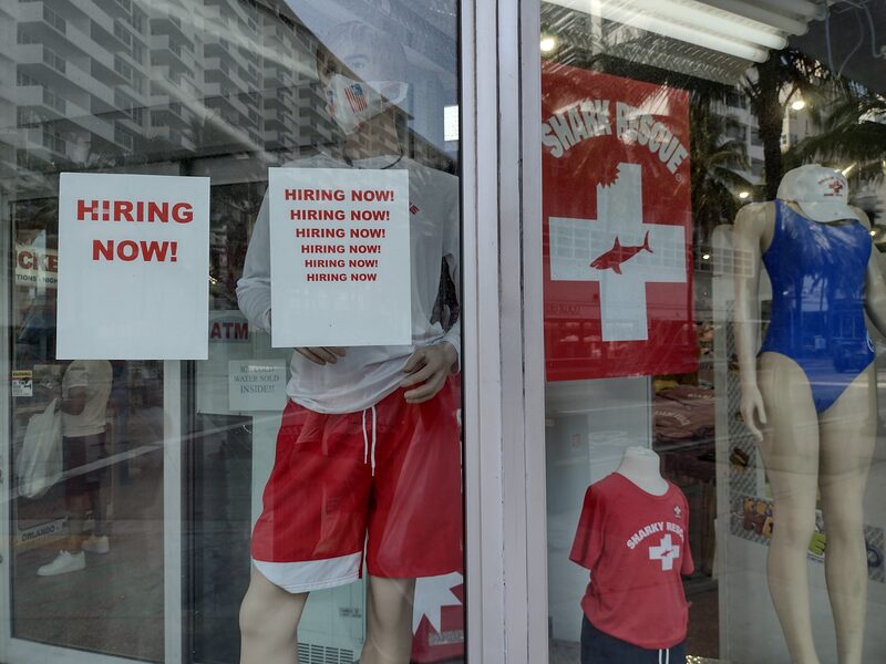 Loja de roupas em Miami Beach anuncia vagas de empregos em vitrine; mercado de trabalho norte-americano busca preencher vagas contratando estrangeiros Loja de roupas em Miami Beach anuncia vagas de empregos em vitrine; mercado de trabalho norte-americano busca preencher vagas contratando estrangeiros