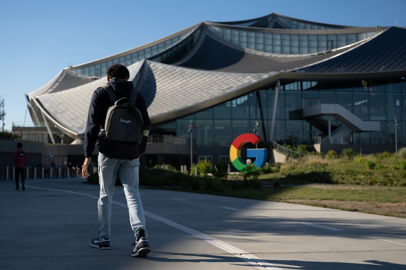 Un joven camina hacia la sede de Google. Un joven camina hacia la sede de Google.