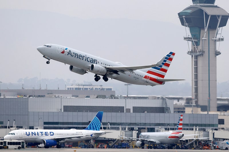 Un avión de American Airlines despega por encima de un avión de United Airlines en la pista del Aeropuerto Internacional de Los Ángeles, en California. Un avión de American Airlines despega por encima de un avión de United Airlines en la pista del Aeropuerto Internacional de Los Ángeles, en California.