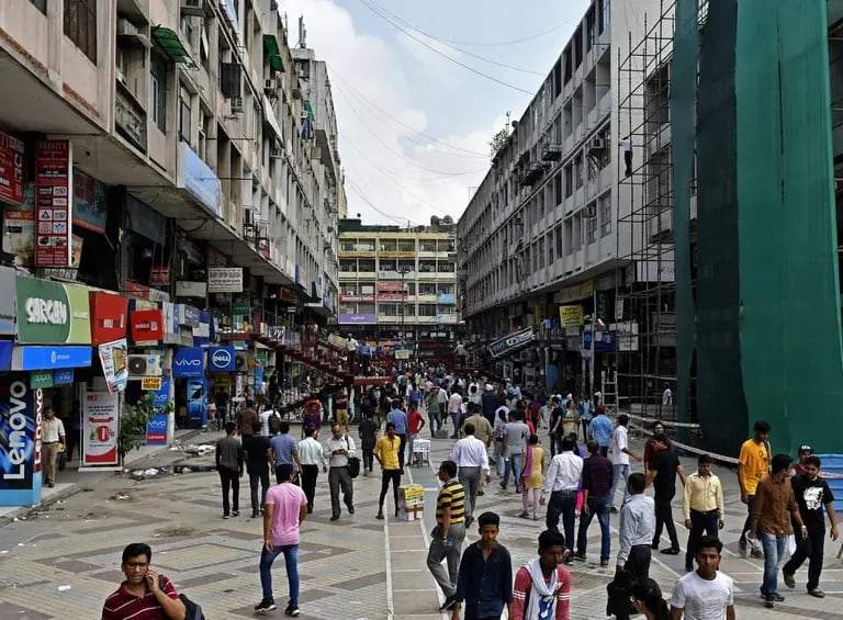 Pedestrians walk along a street in an electronics market in New Delhi, Indiadfd