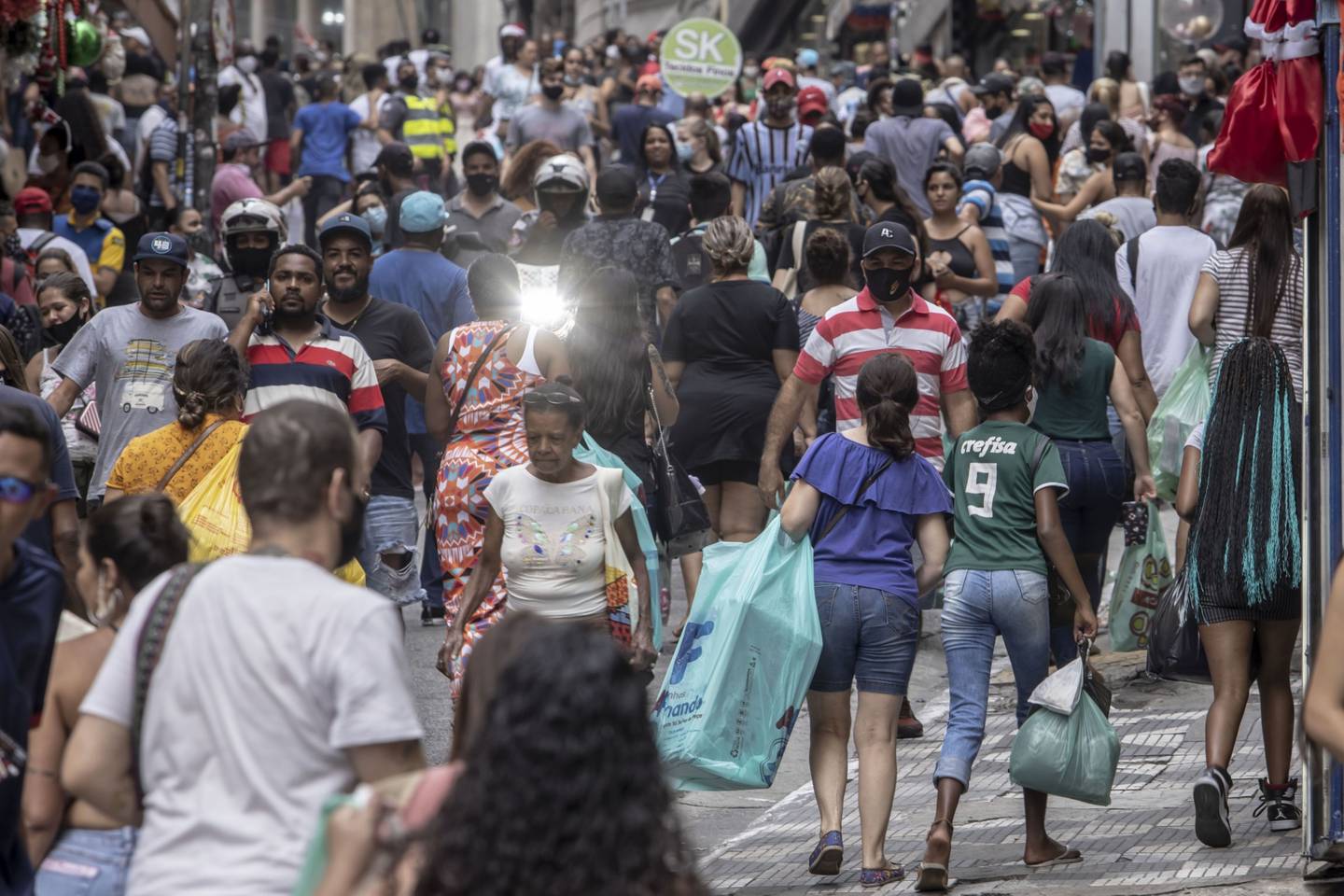 Compradores con mascarillas caminan por la calle 25 de Marco en Sao Paulo, Brasil, el viernes 18 de diciembre de 2020. Esta semana, Brasil alcanzó los 7 millones de casos de coronavirus, ya que las infecciones se aceleran justo antes de la temporada de vacaciones. Fotógrafo: Jonne Roriz/Bloomberg