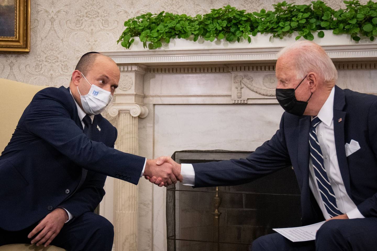 El presidente Joe Biden le da la mano al primer ministro israelí Naftali Bennett durante una reunión
