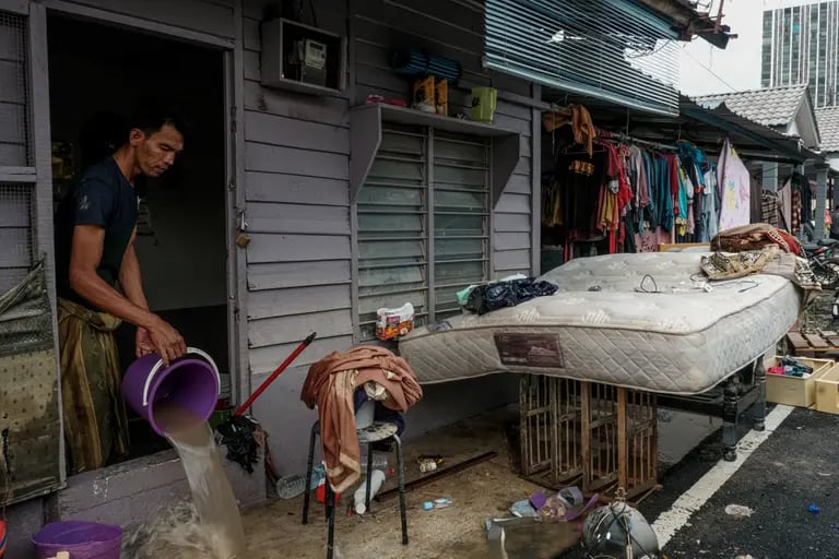 Un residente saca el agua de las inundaciones de una casa en Padang Jawa, Selangor, Malasia, 20 de diciembre de 2021. Fotógrafo: Samsul Said/Bloombergdfd
