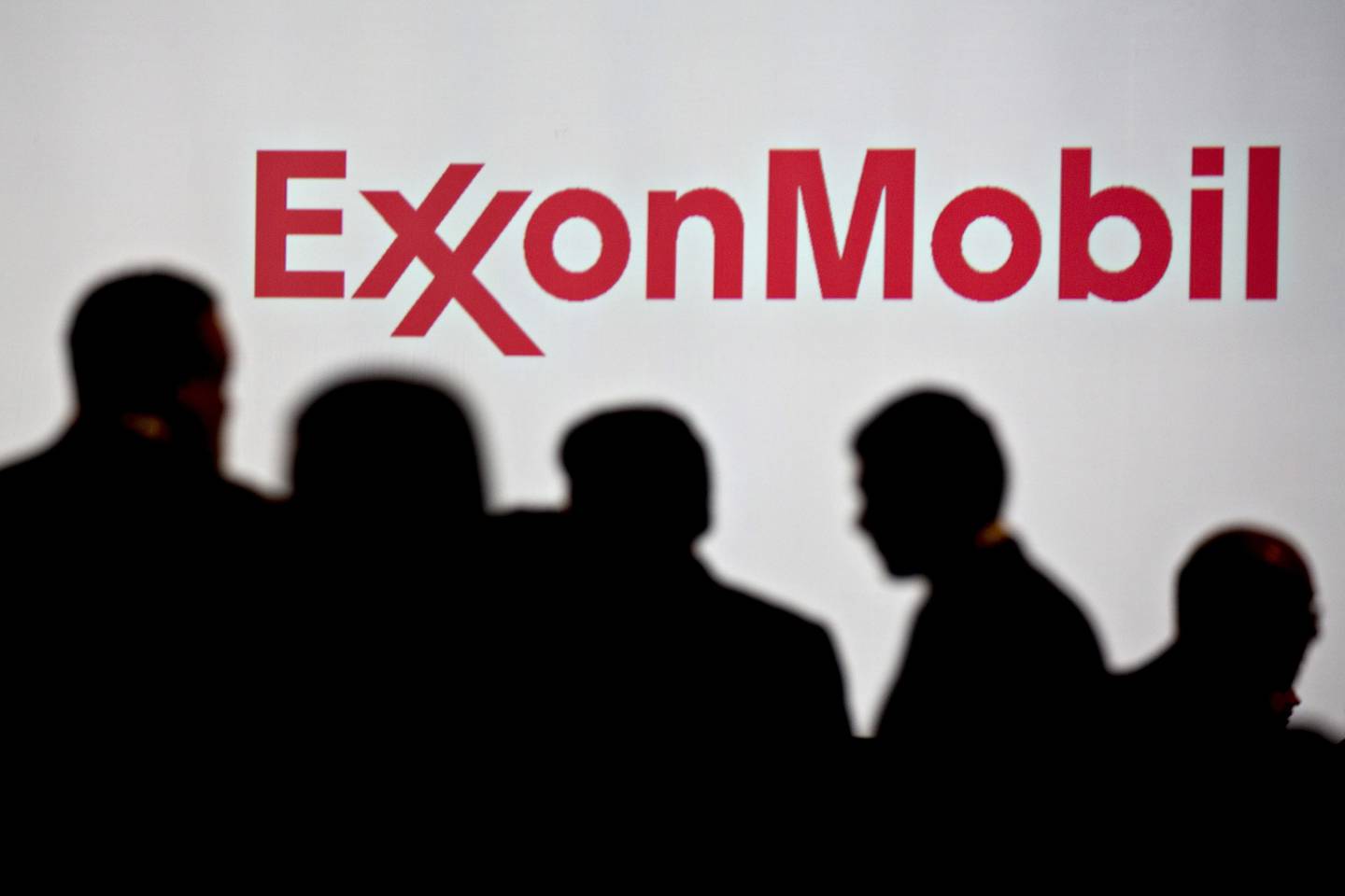 Personas permanecen cerca de la señalización de Exxon Mobil Corp. durante la Conferencia Mundial del Gas en Washington, D.C., Estados Unidos, el martes 26 de junio de 2018.