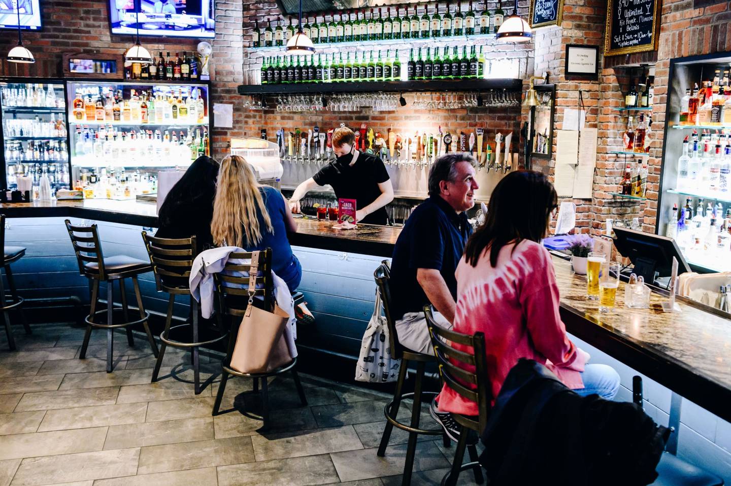 Customers sit at the bar at the Chelsea Bell restaurant in New York.