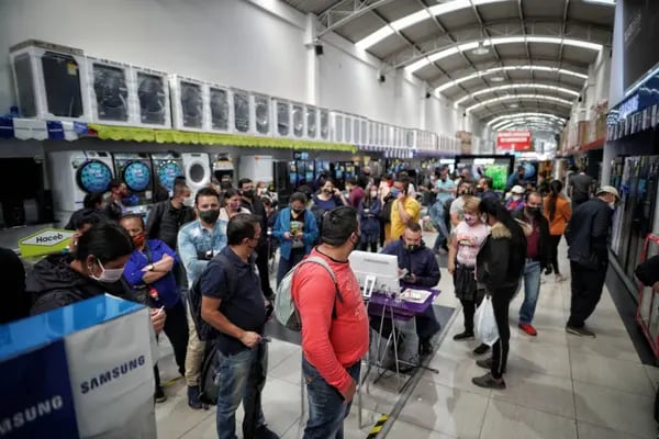 Los compradores con máscaras protectoras revisan electrodomésticos en una tienda de electrónica en Bogotá, Colombia, el viernes 19 de junio de 2020.