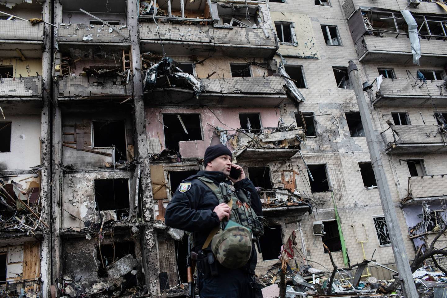 Un policía en el exterior de un edificio dañado tras una explosión ocurrida la madrugada del viernes durante los ataques de la artillería rusa en Kiev-