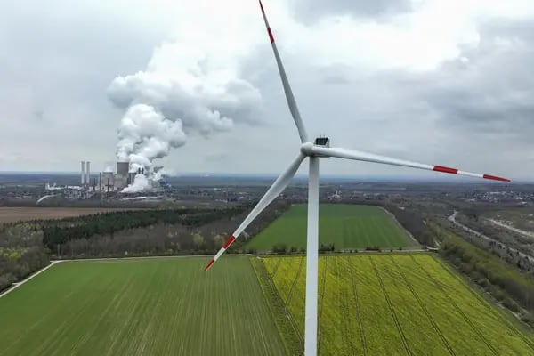 Torres de refrigeración emiten vapor en la central eléctrica de lignito de Niederaussem, operada por RWE AG, más allá de una turbina eólica en Bergheim Niederaussem, Alemania, el viernes 8 de abril de 2022.