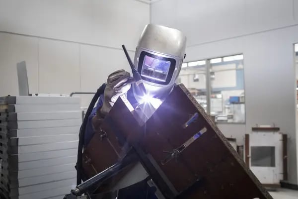 Un empleado suelda metal en la línea de fabricación de electrodomésticos y muebles de cocina en la planta de producción de Challenger SAS en Bogotá, Colombia, el martes 20 de febrero de 2018.