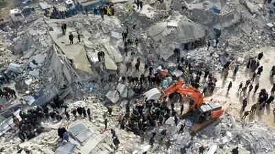 Vista aérea mostra moradores, auxiliados por equipamentos pesados, procurando vítimas e sobreviventes em meio aos escombros de edifícios desmoronados após um terremoto na vila de Besnia, no noroeste da Síria, fronteira com a Turquia (Foto: Omar Haj Kadour/AFP/Getty Images)