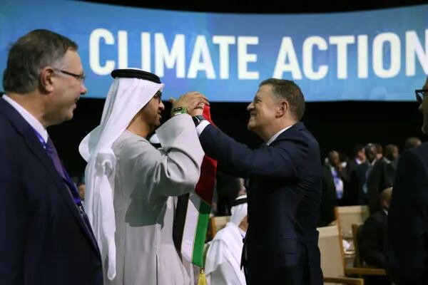 Majid Jafar, CEO de Crescent Petroleum Co., a la derecha, entrega a Sultan Ahmed Al Jaber, CEO de Abu Dhabi National Oil Co. (ADNOC) y presidente de la COP28, en el centro, un pañuelo con los colores de la bandera nacional de Emiratos Árabes Unidos durante la Cumbre sobre el Metano y Otros Gases de Efecto Invernadero distintos del CO2, el tercer día de la conferencia sobre el clima COP28, en la Expo City de Dubai, Emiratos Árabes Unidos, el sábado 2 de diciembre de 2023.