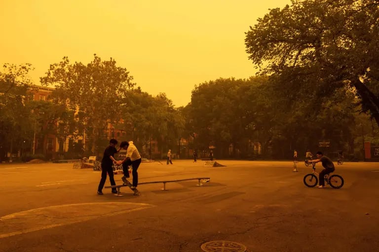 Pedestrians in a skate park as smoke from Canada wildfires blankets New York, US, on Wednesday, June 7, 2023. The US Northeast, including New York City, will continue to breathe in choking smoke from fires across eastern Canada for the next few days, raising health alarms across impacted areas.dfd