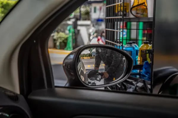 Un trabajador recarga combustible en una estación de servicios al vehículo de un cliente de la gasolinera con la marca de Petróleos Mexicanos, conocida como Pemex en la Ciudad de México.