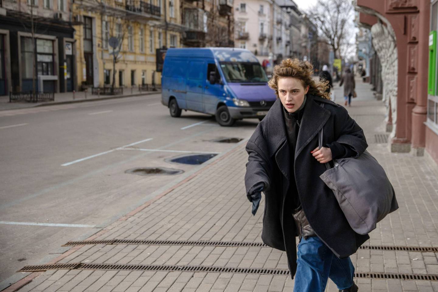 Una residente corre por una calle casi vacía después de que suenen las sirenas antiaéreas en el centro de Kiev.dfd