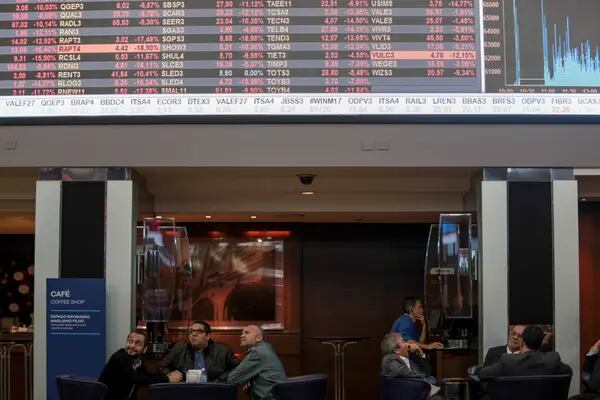Visitors view the electronic board displaying stock activity at the Brasil Bolsa Bacao (B3) stock exchange in São Paulo, Brazil. Photographer: Patricia Monteiro/Bloomberg