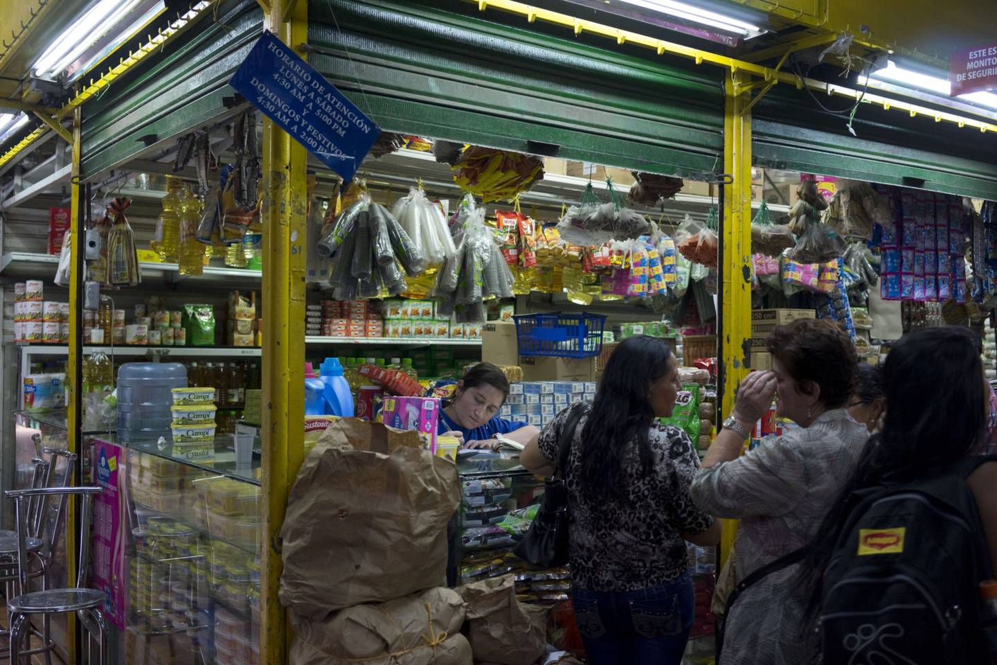 La gente compra comestibles y otros productos en un mercado en el barrio del Prado de Medellín, Colombia.