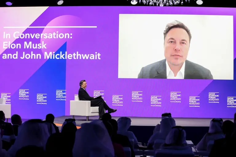 Elon Musk, CEO de Tesla Inc. (a la derecha), aparece por videoconferencia junto a John Micklethwait, redactor jefe de Bloomberg News, durante el Foro Económico de Qatar (QEF) en Doha, Qatar, el martes 21 de junio de 2022. El segundo Foro Económico de Qatar convoca a líderes empresariales y jefes de Estado de todo el mundo para abordar algunos de los retos más urgentes del mundo, a través de la lente de Medio Oriente.dfd