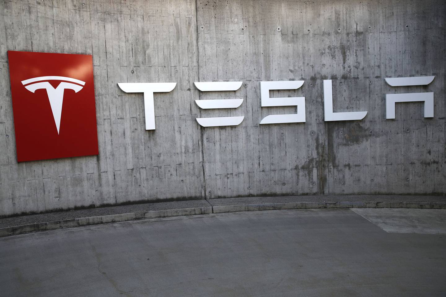 Un logotipo de la compañía cuelga fuera de una tienda de Tesla Inc. en Berna, Suiza, el jueves 16 de agosto de 2018. Fotógrafo: Stefan Wermuth/Bloomberg