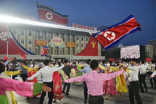 Estudiantes y jóvenes asisten a una fiesta de baile para celebrar el 110º aniversario del nacimiento del presidente Kim Il Sung, conocido como "Día del Sol", en la plaza Kim Il Sung de Pyongyang el 15 de abril de 2022.