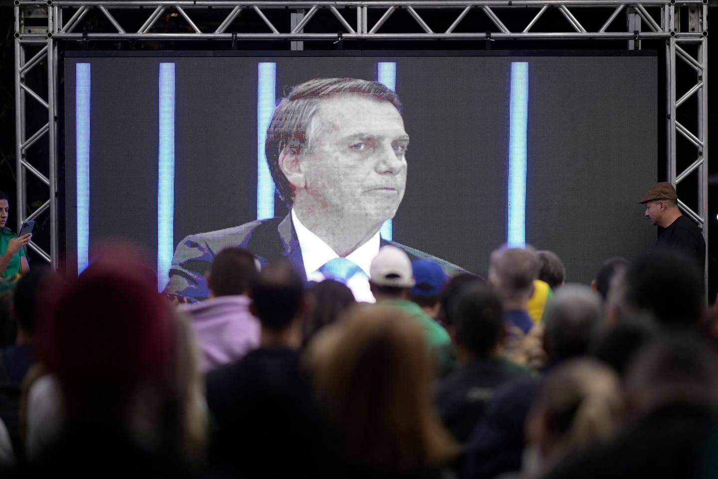 People watch Jair Bolsonaro's interview on a big screen in Minas Gerais State on Aug. 22.