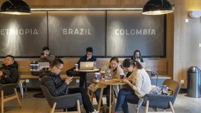 Customers use mobile devices while sitting at tables in a Luckin Coffee outlet in Beijing, China, on Tuesday, Jan. 15, 2019. Luckin, the Chinese startup that's banking on selling cappuccinos to on-the-go office workers, is spending millions of dollars a year opening outlets to unseat Starbucks Corp. as the top java seller in the country. Photographer: Gilles Sabrie/Bloomberg