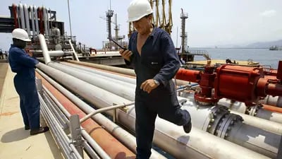 Empleados de Petróleos de Venezuela SA (PDVSA), la compañía petrolera estatal de Venezuela, inspeccionan oleoductos durante una gira de prensa del complejo de refinería El Palito, a unas 150 millas al oeste de Caracas, el viernes 28 de marzo de 2003. 