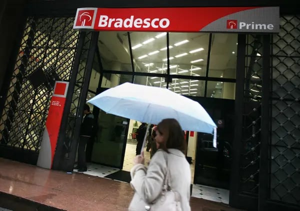 A pedestrian walks past a Bradesco bank branch in Sao Paulo, Brazil.