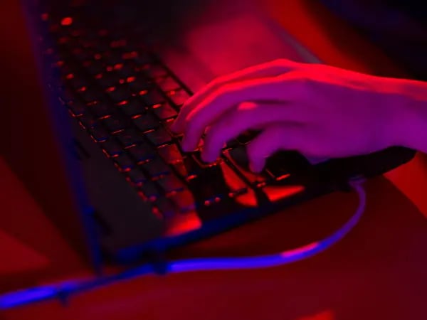 La luz roja ilumina las teclas de una computadora portátil.