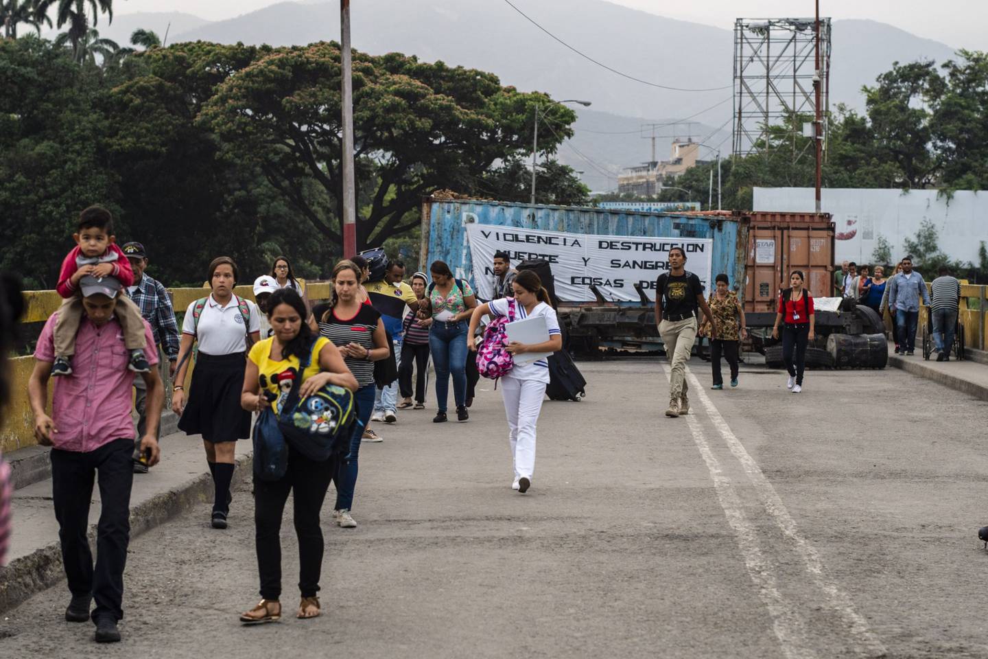 Los venezolanos cargan bolsas de suministros mientras cruzan el Puente Internacional Simón Bolívar cerca de la frontera con Venezuela en Cúcuta, Colombia, el miércoles 27 de marzo de 2019.