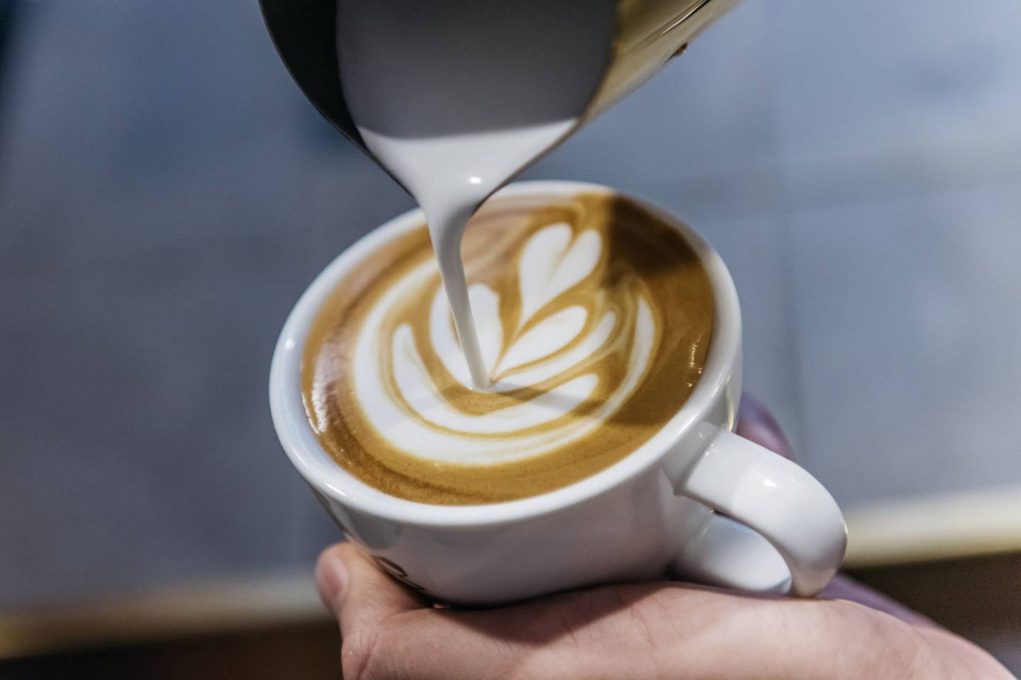 Un empleado vierte café en una taza.