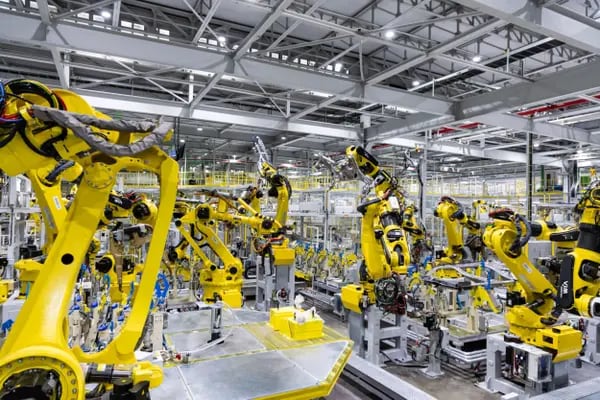 Braços robotizados amarelos em uma fábrica da Kia Motors