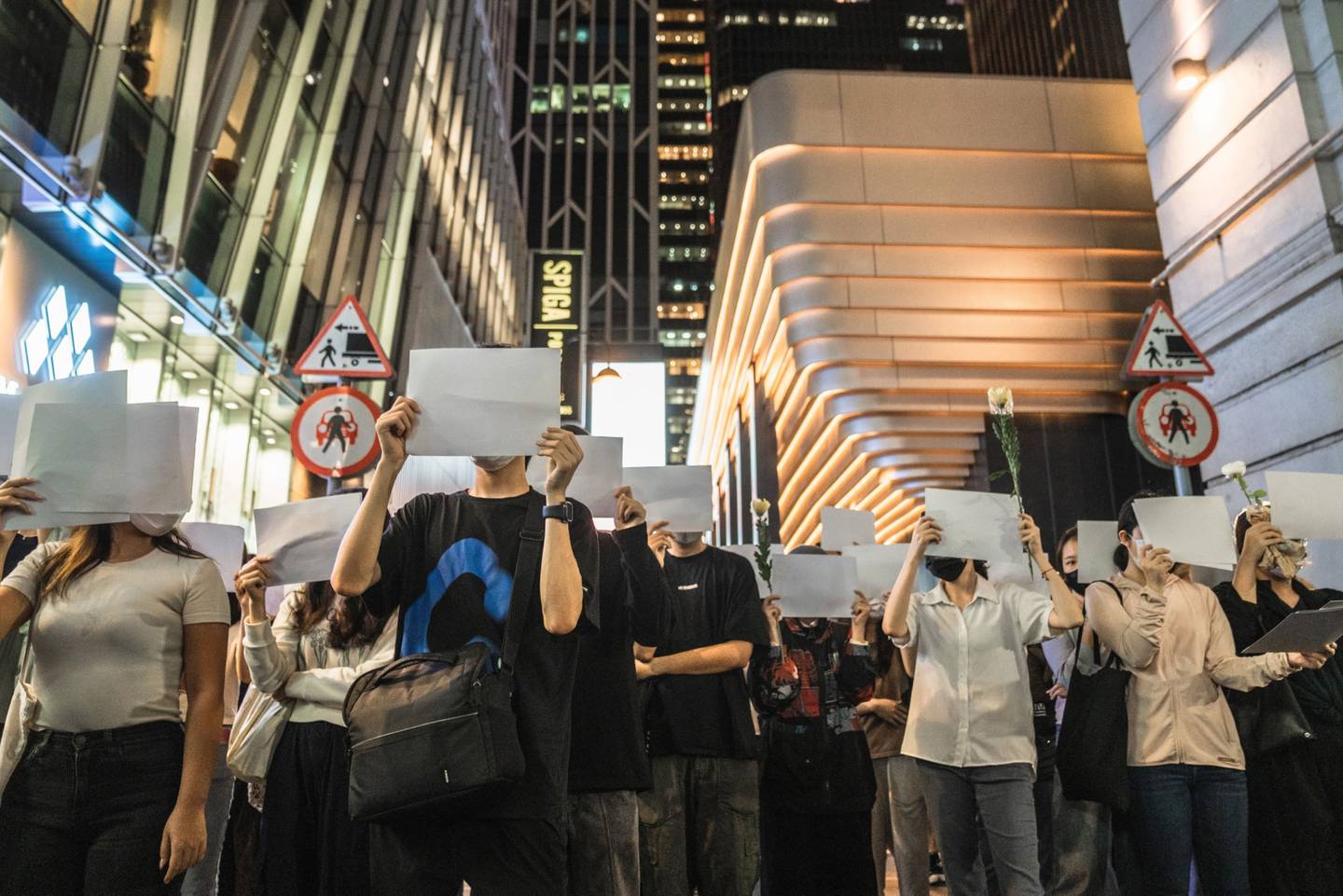 Manifestantes sostienen carteles en blanco durante una vigilia en conmemoración de las víctimas de la política china de Covid Zero en Hong Kong, China, el lunes 28 de noviembre de 2022.