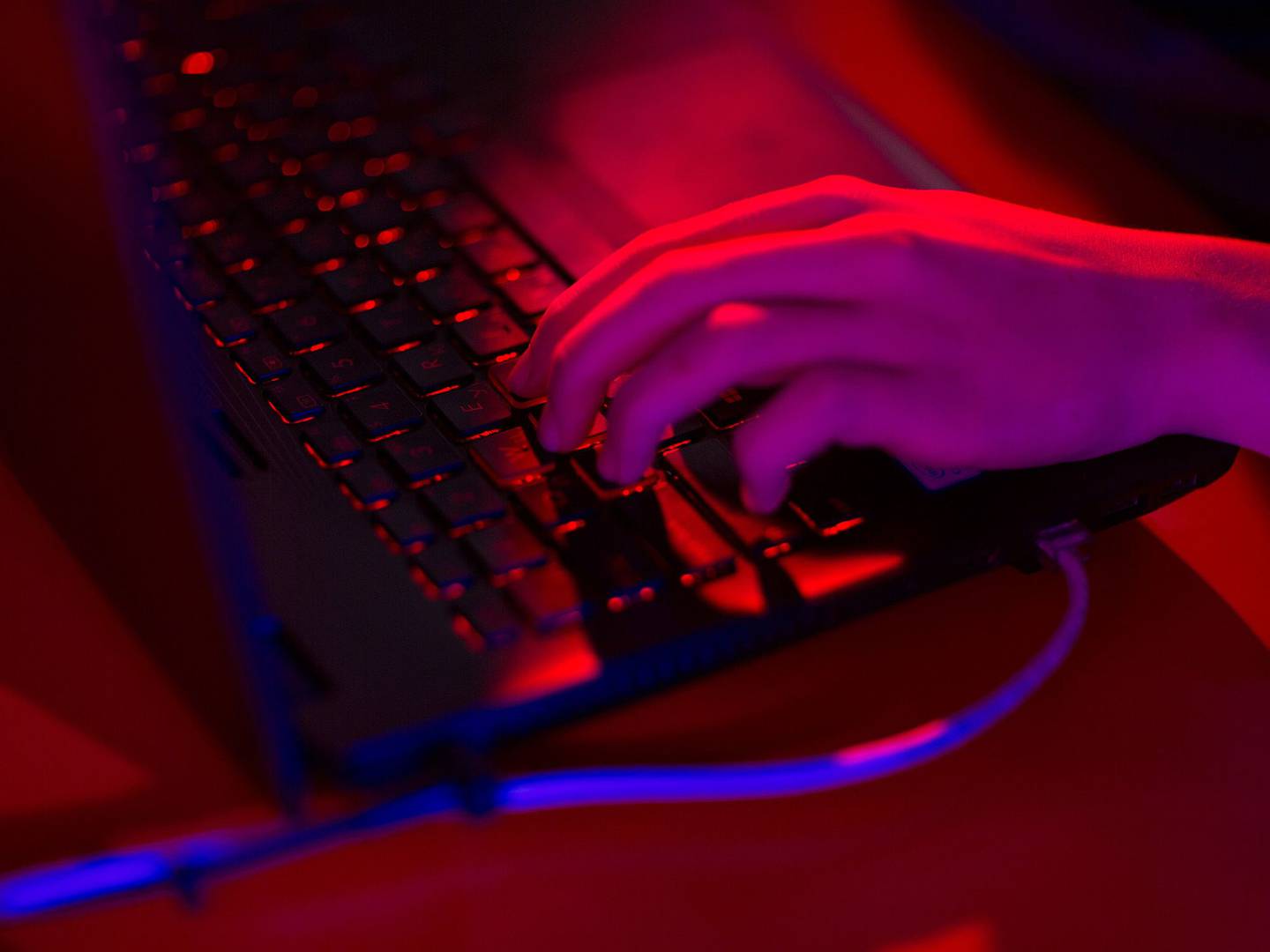 La luz roja ilumina las teclas de un una computadora portátil.