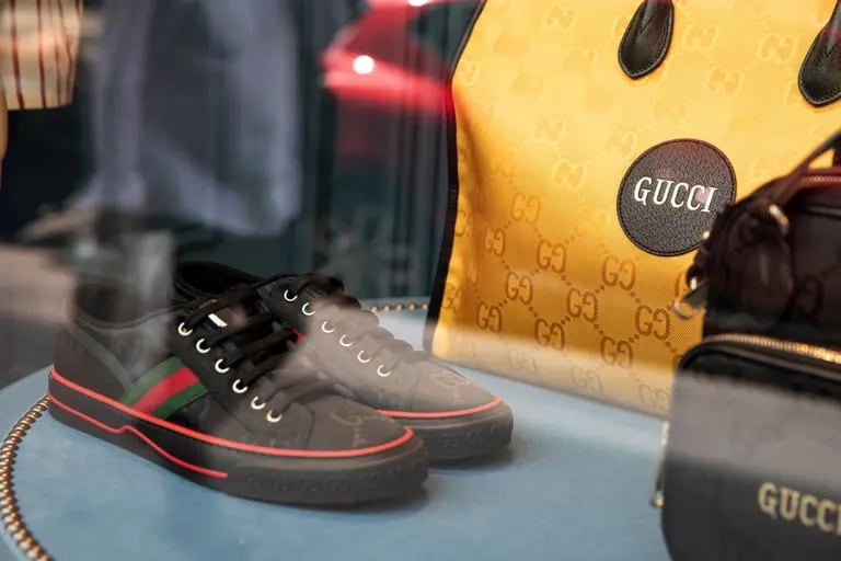 Un par de zapatillas de deporte de lujo y equipaje de cuero en el escaparate de la tienda de artículos de lujo Guccio Gucci SpA, operado por Kering SA, en el distrito de Le Marais en París, Francia, el martes 28 de julio de 2020.dfd