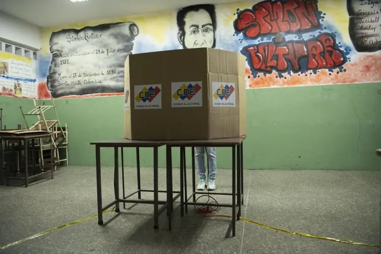 Un elector, con una máscara protectora, emite un voto durante las elecciones parlamentarias, en una escuela en Caracas, Venezuela, el domingo 6 de diciembre de 2020.dfd