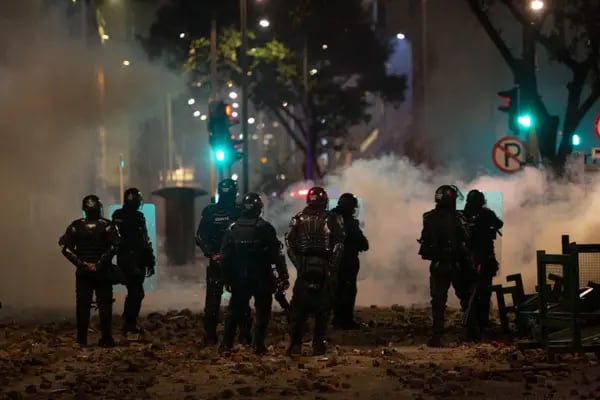 Policías con equipo antidisturbios montan guardia durante una protesta nocturna en Bogotá, Colombia, el martes 21 de enero de 2020